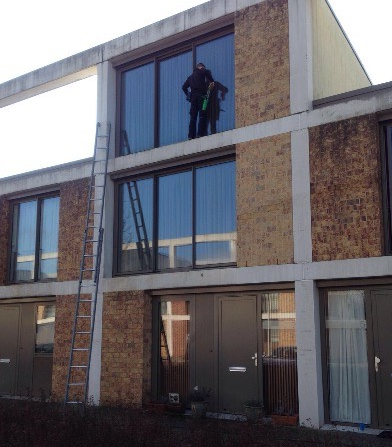 Glazenwasser maakt ramen schoon op de ladder